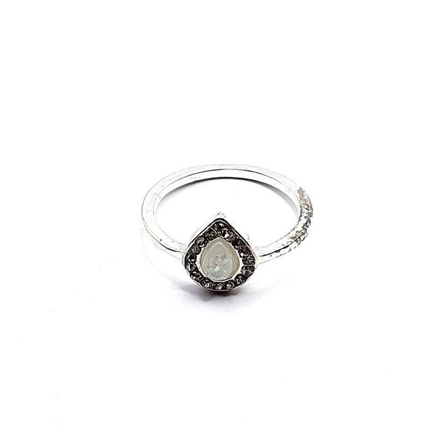 Zilverkleurige ring met druppel-vorm melk-kleurig steentje en rondom strass-steentjes (Ø 18mm)