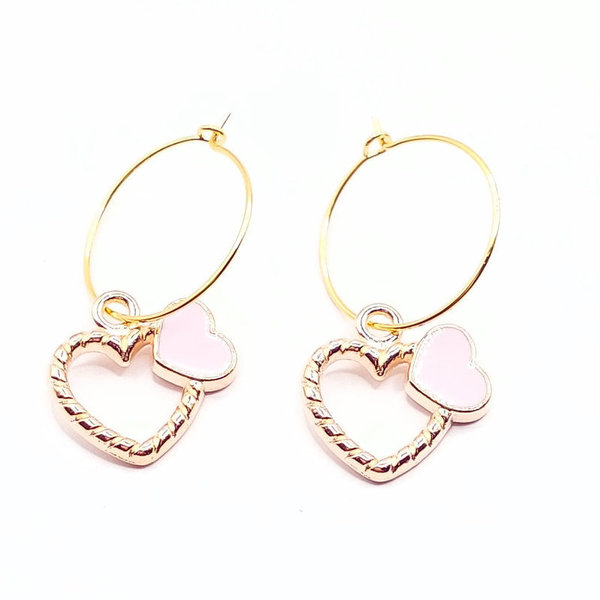 Goudkleurige oorbellen, ringen, open hart en roze hartje